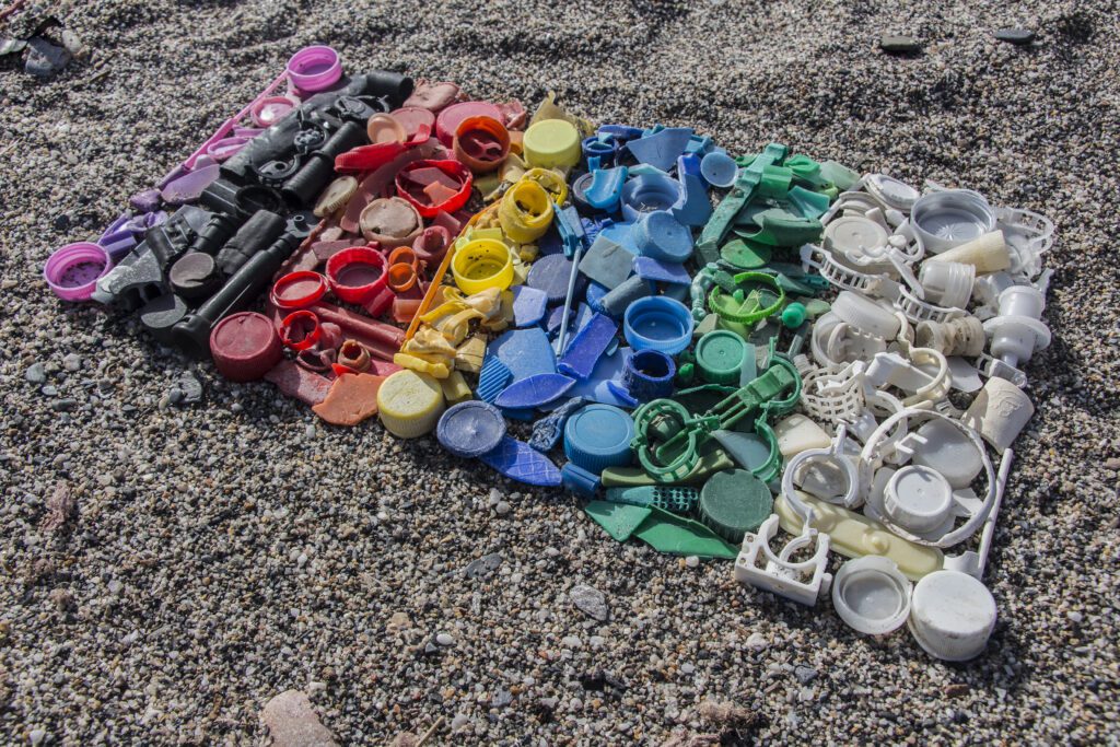 degraded still life of plastic caps and different plastic pieces found on the beach, gradient color of plastic parts
